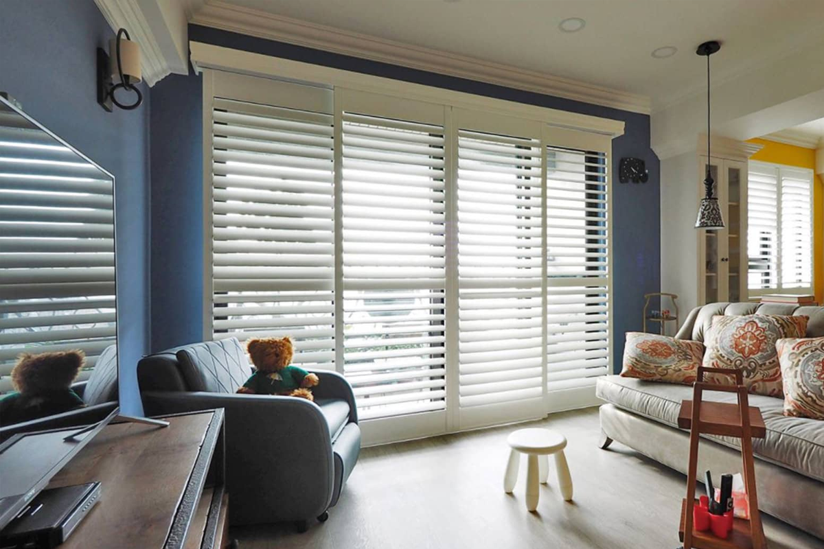 A living room filled with furniture and a window covered in blinds